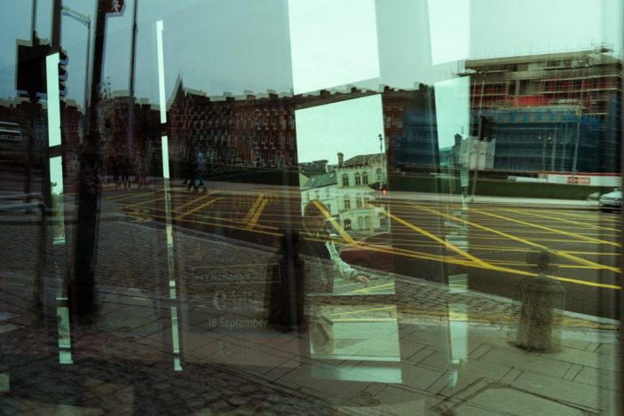 Une rue de cork à travers un abri bus, superpositions, reflets, effets de transparence, abstraction urbaine, couleur